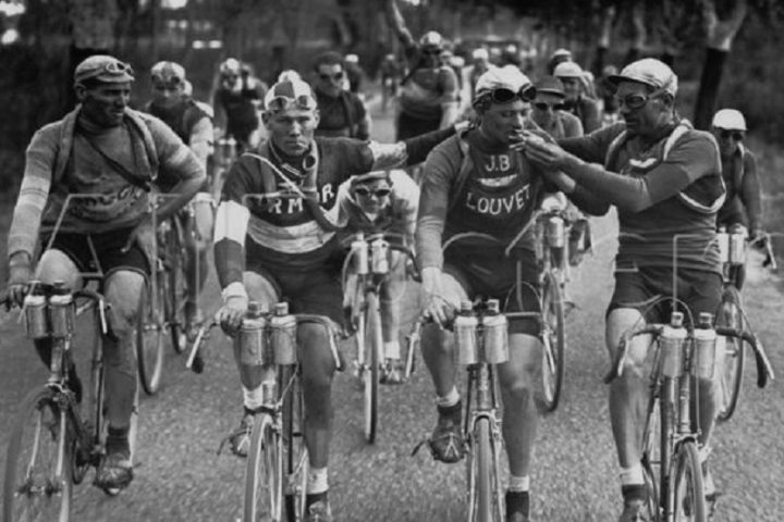 Four cyclists are riding at the front of the race three of the ar smoking cigarettes at Tour de France 1927