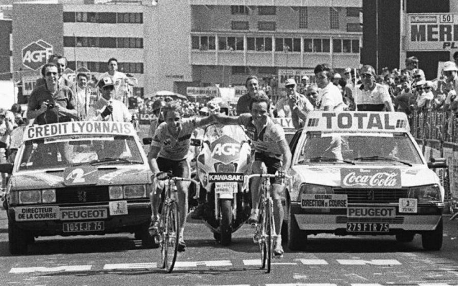 Whit hand in hand and not so sincere smile on the face Greg Lemind and Bernard Hinault crossing the fijish line on Alpe d'Huez at the end of the 18th stage of Tour de France 1986