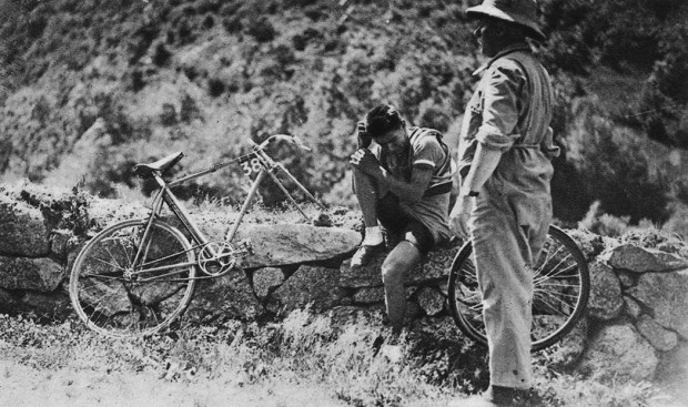 French cyclist René Vietto sitting on rocks at the roadside, crying after had to sacrifice his chance for teamleader Antonin Magne during Tour de France 1934