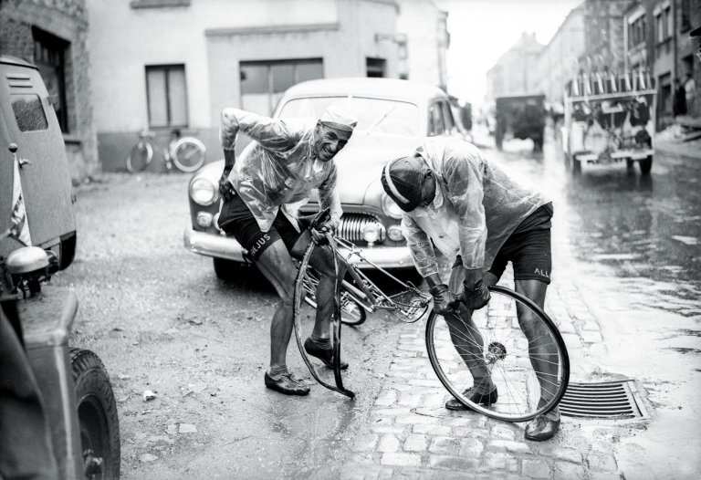 Ferdi Kübler and Emilio Croci-Torti changing wheel in the rain during Tour de France 1950